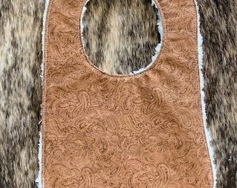 May include: A brown paisley patterned baby bib with a white sherpa trim.