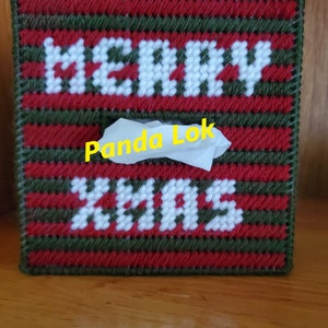May include: A red and green striped tissue box cover with white yarn letters that spell "Merry Xmas". The tissue box cover is handmade and has a white tissue box inside.