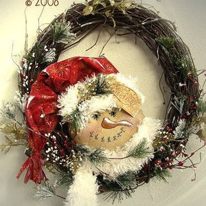 May include: A snowman wreath with a red hat, white fur trim, and a sign that says "Season's Greetings".