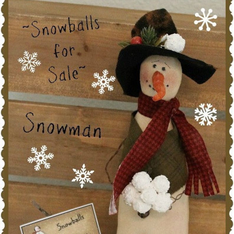 May include: A handmade snowman doll with a black hat, red and white scarf, and a green vest. The snowman is holding a bunch of white snowballs. The background is a wooden wall with the text "Snowballs for Sale" and "Snowman" written on it.
