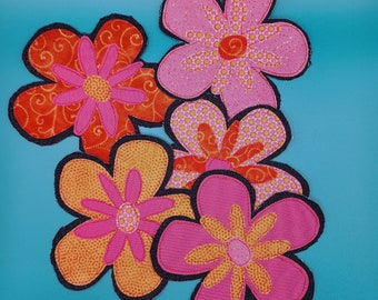 May include: Five fabric flower appliques in shades of pink, orange, and yellow. The flowers have a retro, 1970s style.
