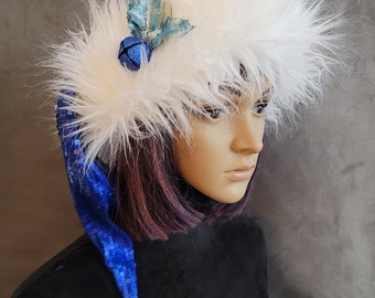 Puede incluir: Un gorro de Papá Noel de piel sintética blanca con ribete azul de lentejuelas y un adorno de acebo azul y plateado.
