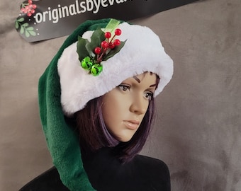May include: Green and white elf hat with a white pom-pom and a holly sprig with red berries and jingle bells.
