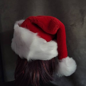 May include: A red and white Santa hat with a fluffy white pom-pom on top.