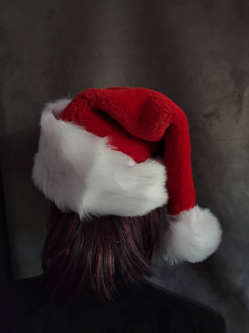 May include: A red and white Santa hat with a fluffy white pom-pom on top.
