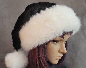 Könnte beinhalten: Ein schwarzer Weihnachtsmannhut mit weißem, flauschigem Besatz und einem passenden Bommel. Der Hut ist aus einem weichen, plüschigen Material gefertigt. Der Hut wird auf einem Schaufensterkopf präsentiert.