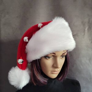 May include: A white and red Santa hat with a white pom-pom and silver jingle bells.