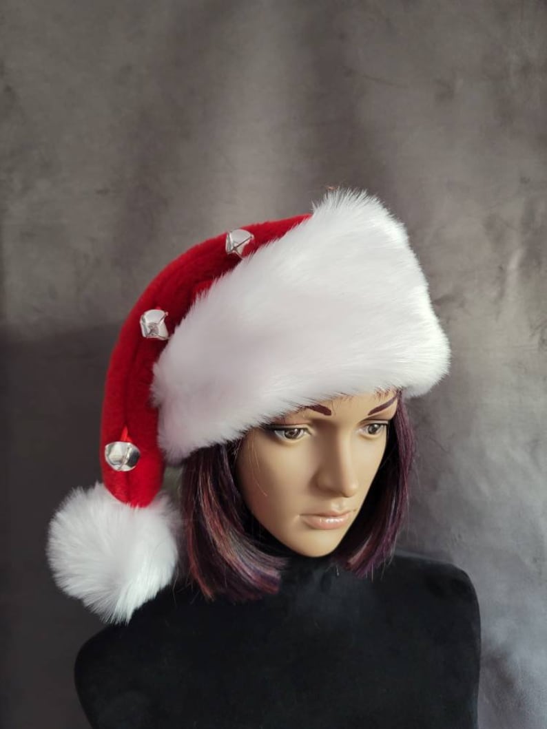May include: A white and red Santa hat with a white pom-pom and silver jingle bells.