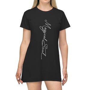May include: A black t-shirt dress with the text "Magical Soul" written vertically in white script.