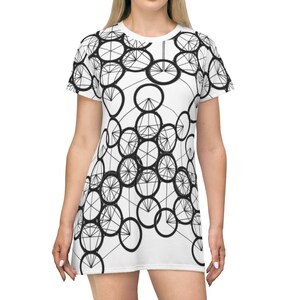 May include: A white t-shirt dress with a black geometric pattern of overlapping circles and lines.