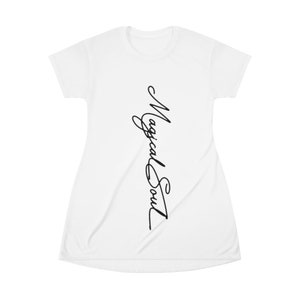 May include: White t-shirt dress with the text "Magical Soul" written vertically in black cursive script.