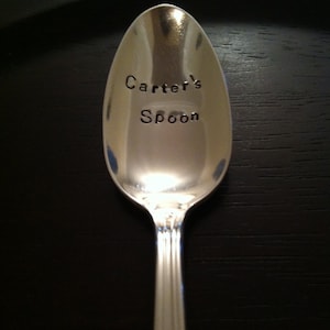 May include: A silver spoon with the words "Carter's Spoon" engraved on the front.