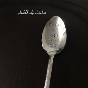 Peut inclure: Une cuillère en argent gravée des mots "You're the GIN to my TONIC".