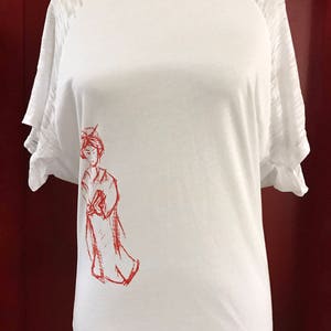 May include: White t-shirt with red raglan sleeves and a red drawing of a woman on the left side of the shirt.