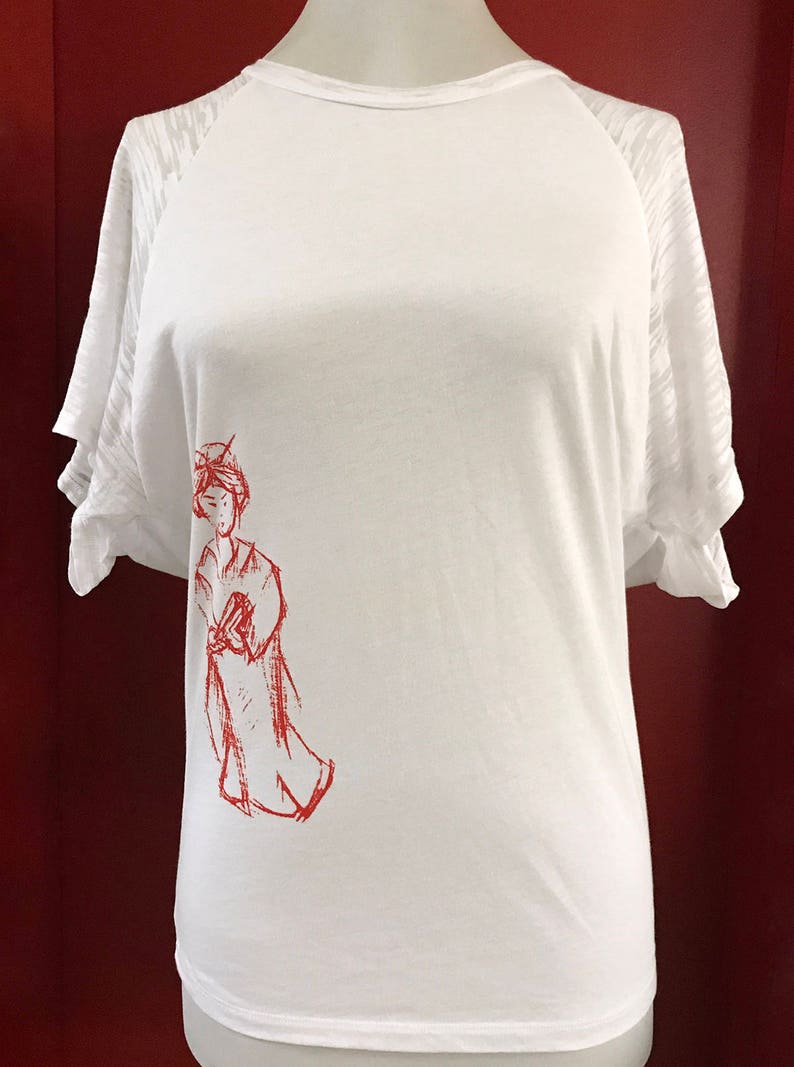 May include: White t-shirt with red raglan sleeves and a red drawing of a woman on the left side of the shirt.
