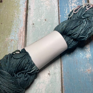 Homegoing | a deep blue green yarn that is also  speckled fingering weight yarn for knitting, crochet, and weaving