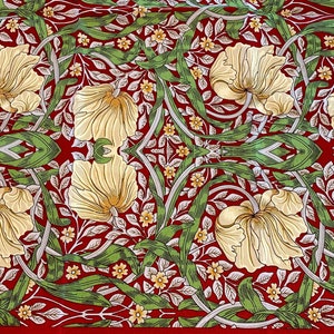May include: A fabric featuring a repeating botanical pattern on a deep red background. The design includes large, cream-colored tulip-like flowers, intertwined with long, flowing green leaves and small yellow blossoms with white centers.