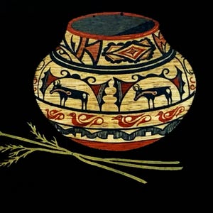 May include: A round ceramic pot featuring a tan base with intricate hand-painted designs in black and red, including depictions of four-legged animals and birds, accompanied by a single long, thin, light green stalk of dried grass.