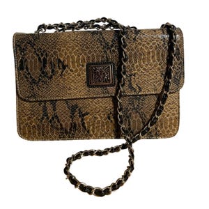 May include: A brown and black snakeskin-patterned handbag with a silver chain strap. The bag has a rectangular shape with a flap closure and a small square emblem on the front.