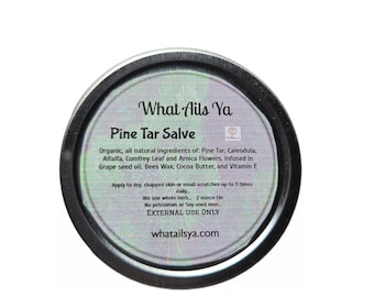 以下が含まれることがあります： 松ヤニ軟膏の丸い缶。ラベルには「What Ails Ya」と「Pine Tar Salve」と書かれています。成分には、松ヤニ、カレンデュラ、アルファルファ、コンフリー、アルニカが含まれています。缶は57グラムです。