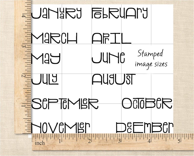 May include: A white square grid with the months of the year printed in black, stylized font. The text "Stamped image sizes" is also present. A wooden ruler with inch measurements is in the image.