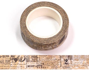 May include: A roll of decorative washi tape with a vintage postage stamp design. The tape features a beige background with printed text and illustrations in black. The tape is approximately 1 inch wide and has a white inner core.
