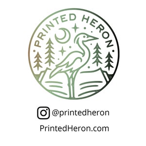 Puede incluir: Logotipo circular con el texto "PRINTED HERON" en el borde. El logotipo presenta una garza frente a monta&ntilde;as y &aacute;rboles, con una luna creciente y estrellas arriba. Debajo del logotipo est&aacute; el nombre de usuario de Instagram "@printedheron" y el sitio web "PrintedHeron.com".