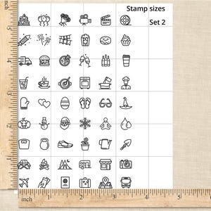 May include: A sheet of paper with a grid of small, black line art stamps. The stamps depict various objects, including food, travel items, and holiday-themed icons. The text "Stamp sizes Set 2" is visible.