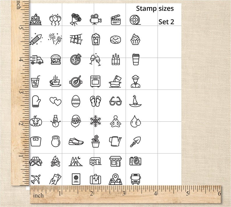 May include: A sheet of paper with a grid of small, black line art stamps. The stamps depict various objects, including food, travel items, and holiday-themed icons. The text "Stamp sizes Set 2" is visible.