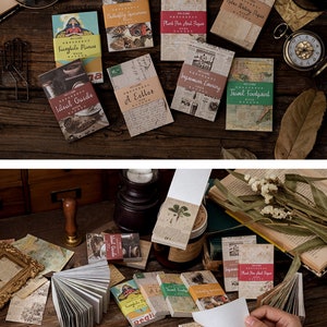 May include: A collection of vintage-style memo pads and notebooks with various designs and text. The pads feature printed covers with images and text, including "Butterfly Specimens" and "Ideal Guide". The color palette includes beige, brown, and touches of red and green.