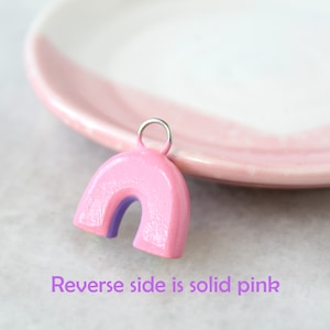 The backside of the rainbow charms, which are solid pink. Text reads "Reverse side is solid pink."