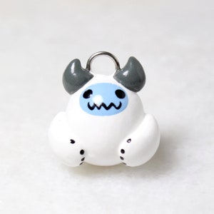 A small yeti snow monster charm with a blue face and gray horns.