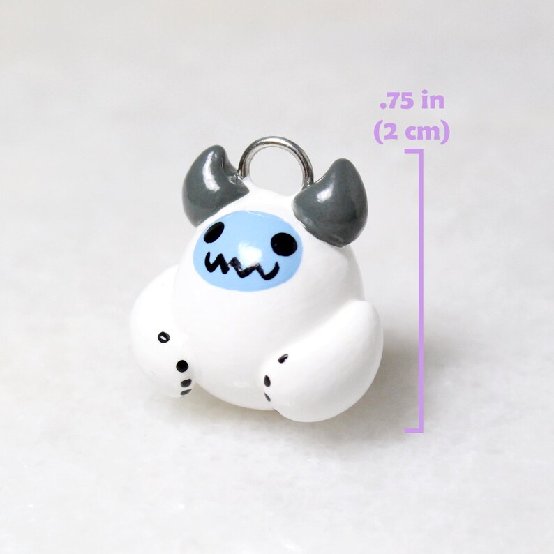 A yeti charm next to a measurement ruler that reads: .75 inches (2 centimeters) tall.