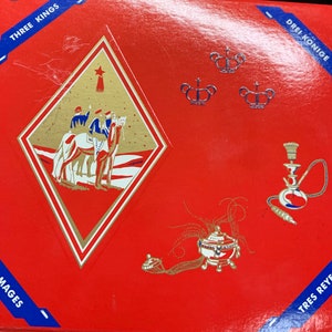 May include: Red box with gold and white illustrations. The box features images of the Three Kings, crowns, and a hookah. Text in blue boxes reads "Three Kings", "Drei Konige", "Trois Mages", and "Tres Reyes".