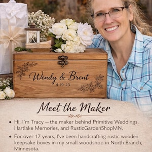 A woman is smiling and posing next to a wooden box with a floral design, surrounded by flowers and other decorative items.
