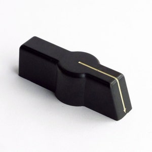 May include: Black plastic knob with a white line down the center. The knob is designed to be turned.