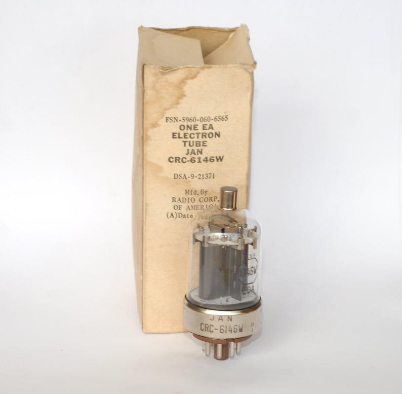 May include: A silver vacuum tube with a glass casing and a metal base. The tube is labeled "JAN CRC-6146W". The tube is in its original box, which is labeled with the part number, manufacturer, and date code.