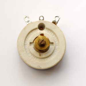 May include: A white ceramic potentiometer with a brass knob. The text on the potentiometer reads "WARD LEONARD TYPE FOR 3000 VOLTS INSULATED".
