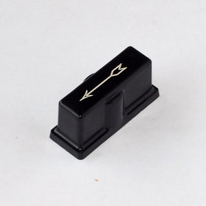 May include: Black plastic knob with a white arrow pointing to the right. The knob is rectangular and has a slightly rounded top.