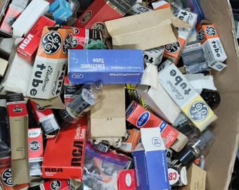 Könnte beinhalten: Ein Karton voller alter Elektronenröhren. Die Röhren sind in verschiedenen Größen und Formen, mit Verpackungen von Marken wie RCA, GE und Westinghouse. Die Kartons sind in verschiedenen Farben, darunter Rot, Blau und Orange.