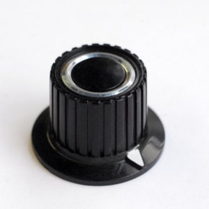 black skirted radio knob with white pointer and chrome ring