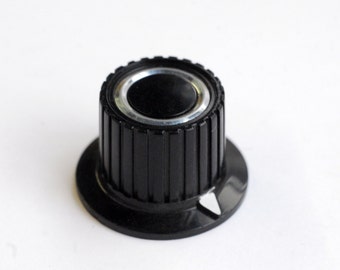 black skirted radio knob with white pointer and chrome ring