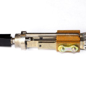 May include: A silver and black toggle switch with a wooden base and three metal terminals. The switch is in the off position.