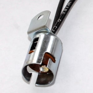May include: A silver metal light bulb socket with two black wires attached. The wires are labeled "WIRE & CA".