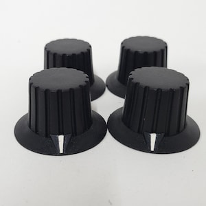 4 Black skirted pointer knobs with white pointer - radio or control knob - black - pebbly surface - grooves for grip - fit 1/4&quot; shafts