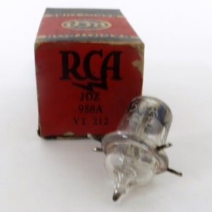 May include: A vintage RCA 958A vacuum tube in its original box. The box is red with black lettering and features the RCA logo. The tube is clear glass with a metal base.