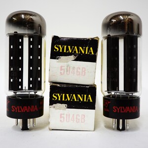 May include: Two vacuum tubes with a glass enclosure and a metallic top, flanked by two boxes. The boxes are labeled "SYLVANIA" in yellow and "5U4GB" in red. The tubes have a black base with the "SYLVANIA" logo.