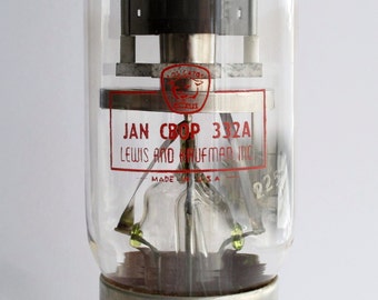 May include: A clear glass vacuum tube with a metal base. The tube has a red label that reads "JAN CBOP 332A LEWIS AND KAUFMAN, INC. MADE IN U.S.A. 225".