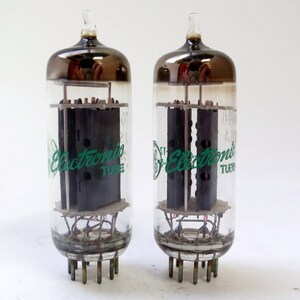 May include: Two vintage vacuum tubes with clear glass bodies and dark gray tops. Each tube has internal components and a green logo that reads "Electronic TUBE". The tubes have multiple pins at the base.