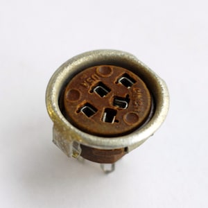 May include: A close-up of a silver and brown electrical connector with the text "USSR" and "GIMAZI" printed on it.